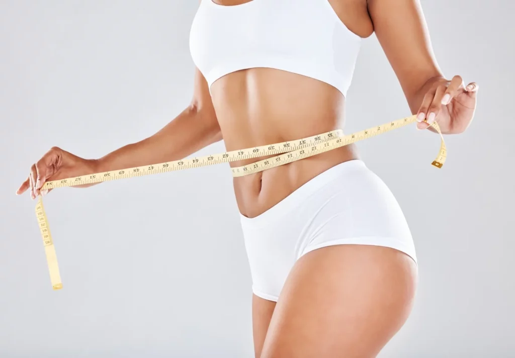 Portfolio 2 Woman measuring her waist with a tape measure, promoting weight loss services at Evolve HRT & Wellness in The Woodlands, TX